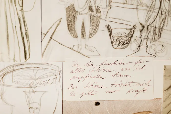 Überlappende Papiere mit Zeichnungen und Schrift