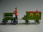 Figur auf einem Traktor zieht einen Wohnwagen