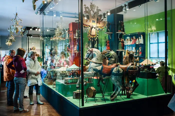 Besucher schauen sich eine große Vitrine mit Objekten an