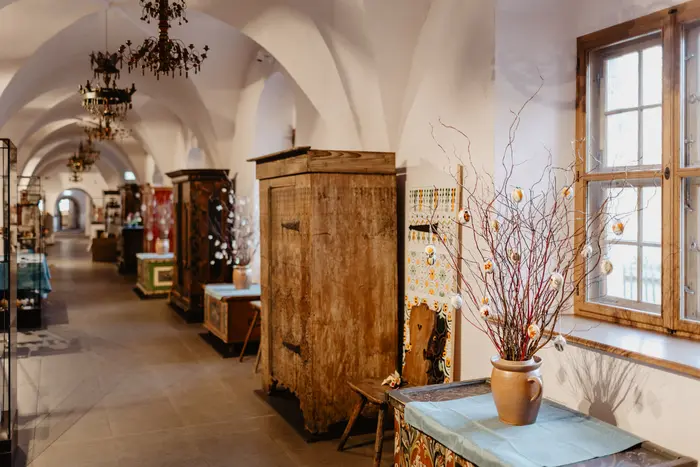 Langer Gang mit alten Möbeln und Ostersträußen