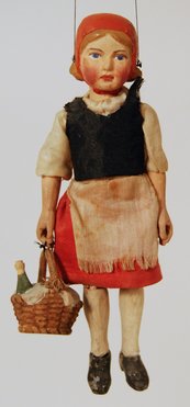 Marionette eines Mädchens mit Kleid, Käppchen und einem Korb in der Hand