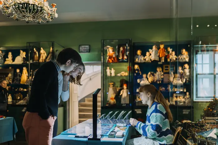 zwei Frauen betrachten Volkskunststand