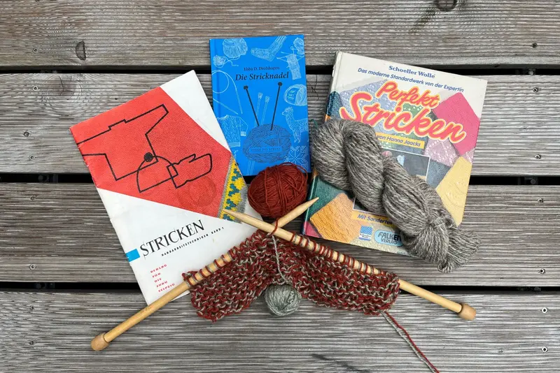 verschiedene Bücher und Strickutensilien