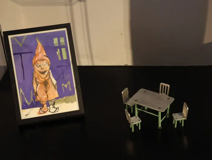 Zeichnung auf einem Tisch stehend mit einem Miniatur-Tisch mit Stühlen.