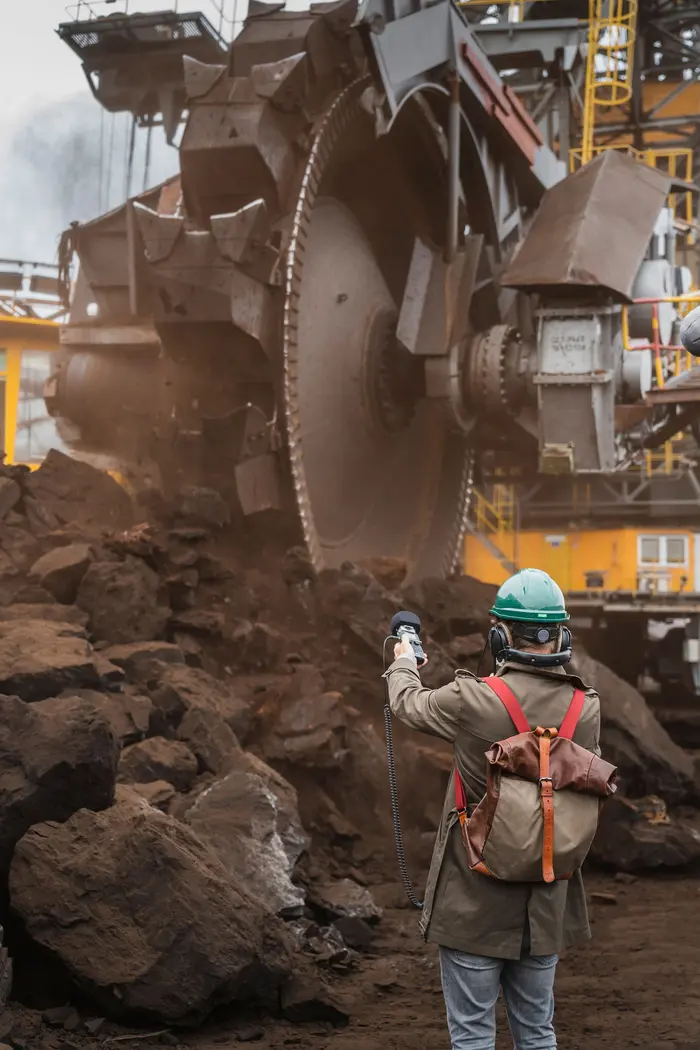 Ein Mensch mit Helm auf einer Baustelle.