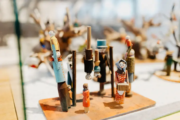 Kleine Holzfiguren in einer Vitrine