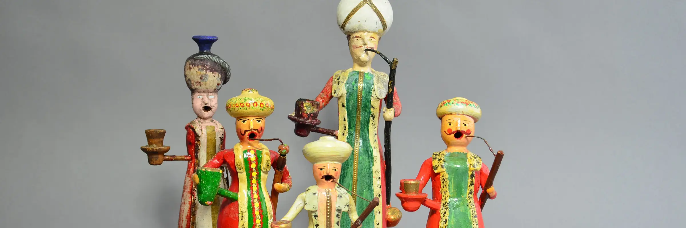 Türkische Figuren in bunter Kleidung, rauchend dargestellt.