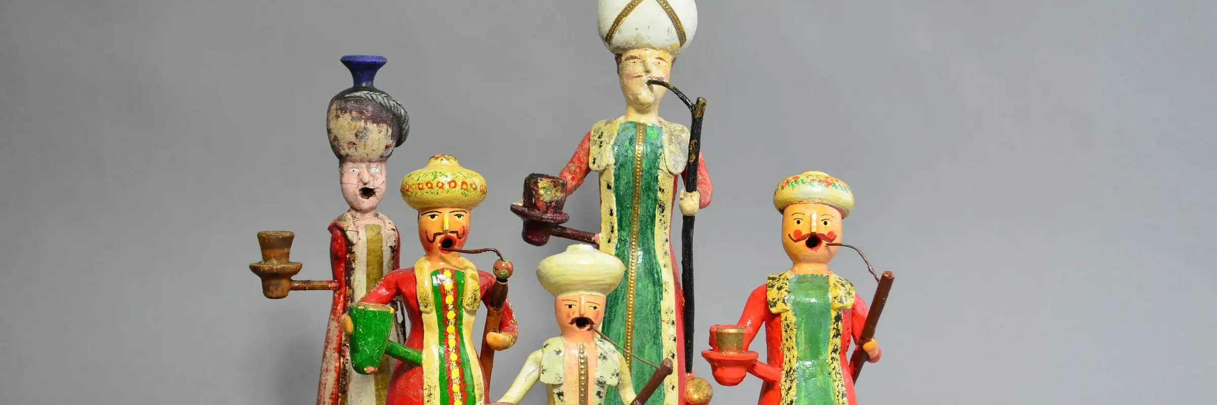 Türkische Figuren in bunter Kleidung, rauchend dargestellt.