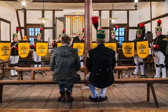 Zwei Männer, die einem Orchester zuhören.