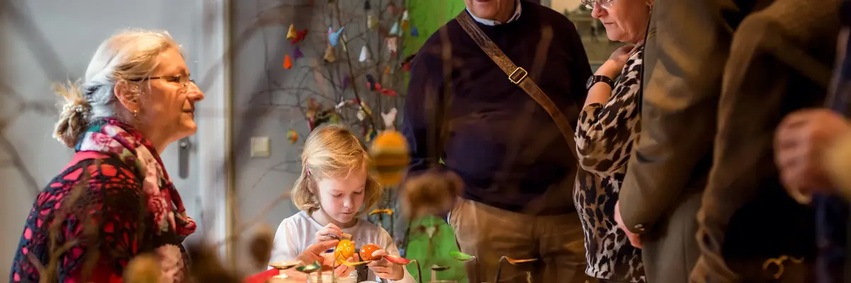 Tisch mit Ostereiern, drumherum Besucher