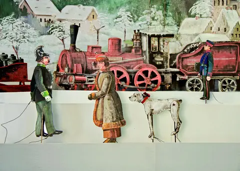 Lokomotive in einer Winterlandschaft, zwei Offiziere, ein weiterer Mann und ein Hund