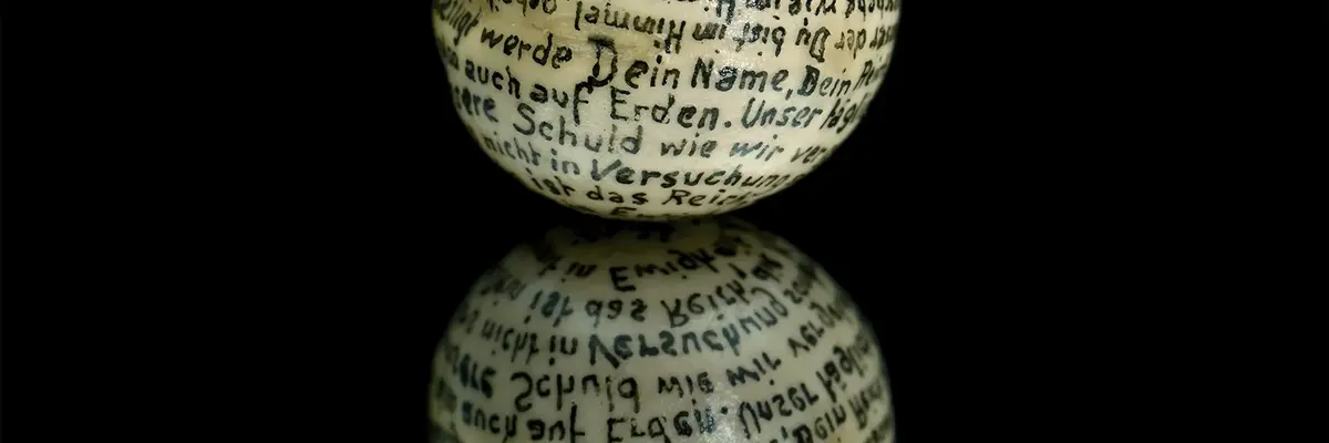 weiße Kugel mit Schrift auf schwarzem Untergrund