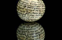 Moritz Schubert, Mit einem Gebet handbeschriebene Erbse, Schwerin, 1937 weiße Kugel mit Schrift auf schwarzem Untergrund
