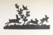 Silhouette von drei laufenden Kaninchen, einem Vogel und einem Zweig
